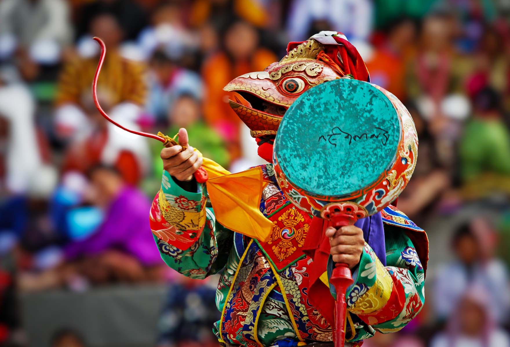 A masked dancer performing at a Bhutanese festival